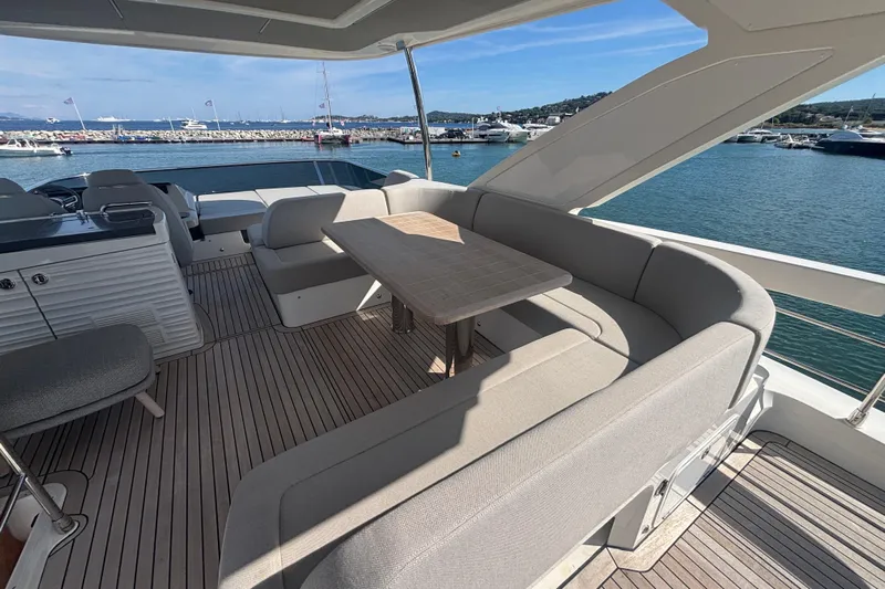  Yacht Photos Pics Luxurious 2023 Absolute 60 Fly yacht with elegant outdoor seating and scenic marina view.