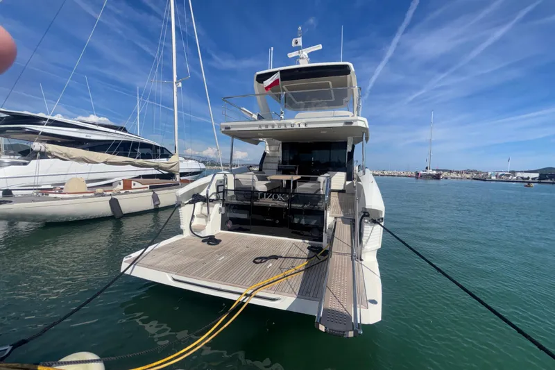  Yacht Photos Pics 2023 Absolute 60 Fly yacht docked at marina under clear blue sky.