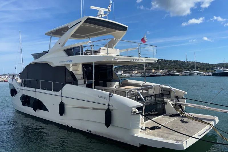  Yacht Photos Pics 2023 Absolute 60 Fly yacht docked at marina under blue sky.