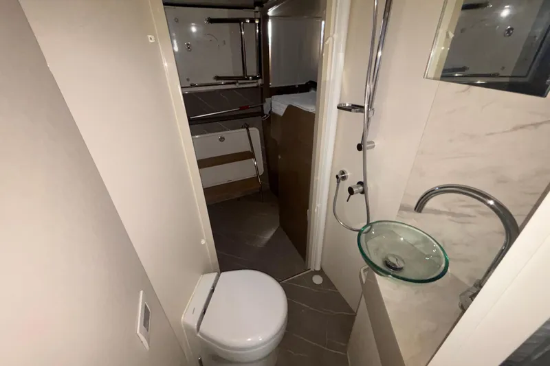  Yacht Photos Pics Bathroom interior of 2023 Absolute 60 Fly yacht with modern fixtures and glass sink.