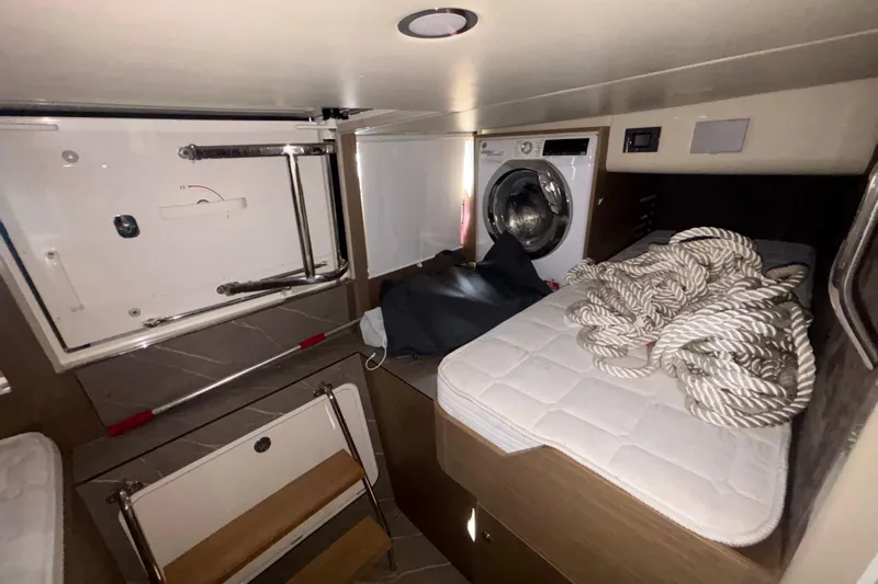  Yacht Photos Pics Interior of 2023 Absolute 60 Fly yacht with washing machine and storage area.