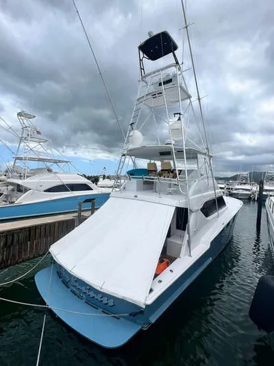  Yacht Photos Pics 2001 Hatteras 60 Convertible yacht docked at marina under cloudy sky.