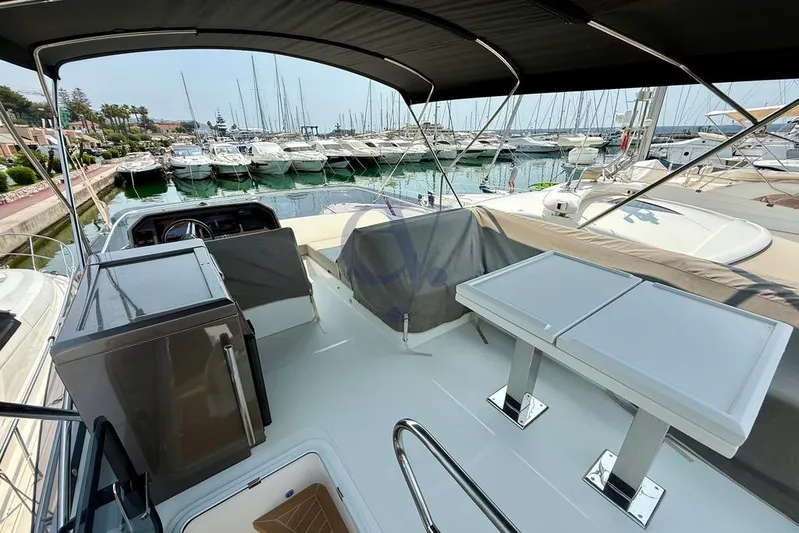 Yacht Photos Pics 2022 Galeon 460 Fly yacht interior with seating and tables, docked at a marina.