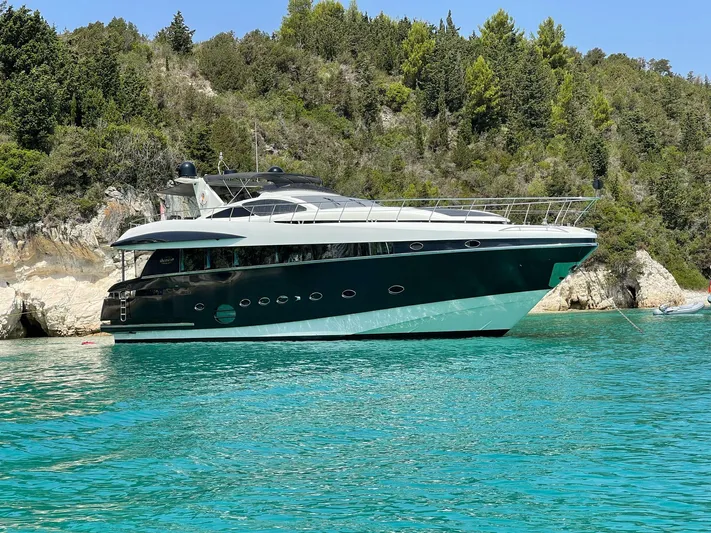  Yacht Photos Pics 2008 Conam 75 Widebody yacht on turquoise water near a rocky shoreline.