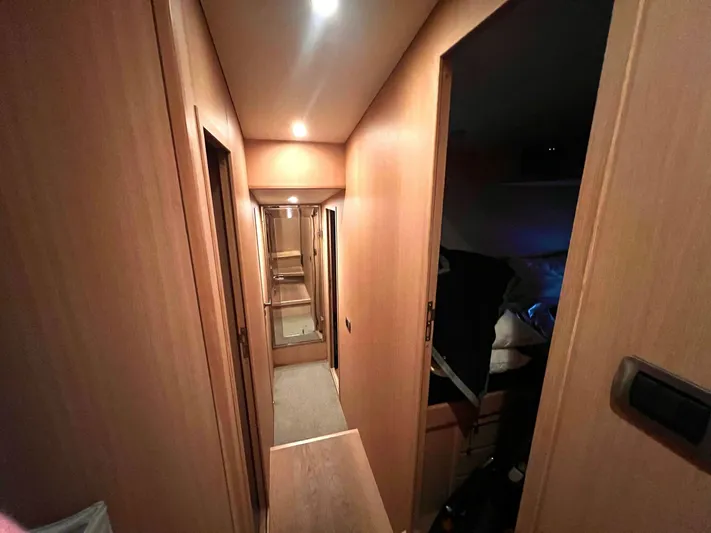  Yacht Photos Pics Narrow hallway inside 2008 Conam 75 Widebody yacht with wooden paneling and soft lighting.