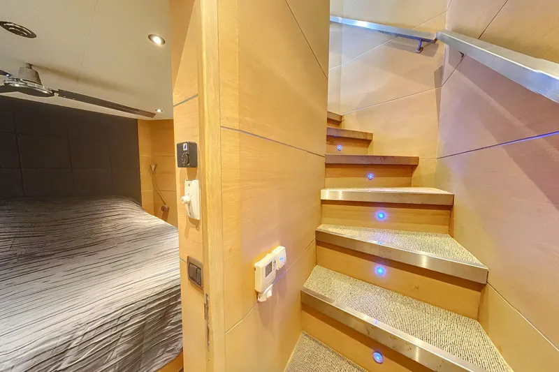  Yacht Photos Pics Interior of 2008 Conam 75 Widebody yacht with wooden stairs and cozy bedroom.