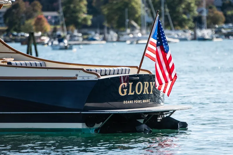 Glory Yacht Photos Pics 2013 Hinckley Talaria 34 boat with American flag, named "Glory," on calm water.