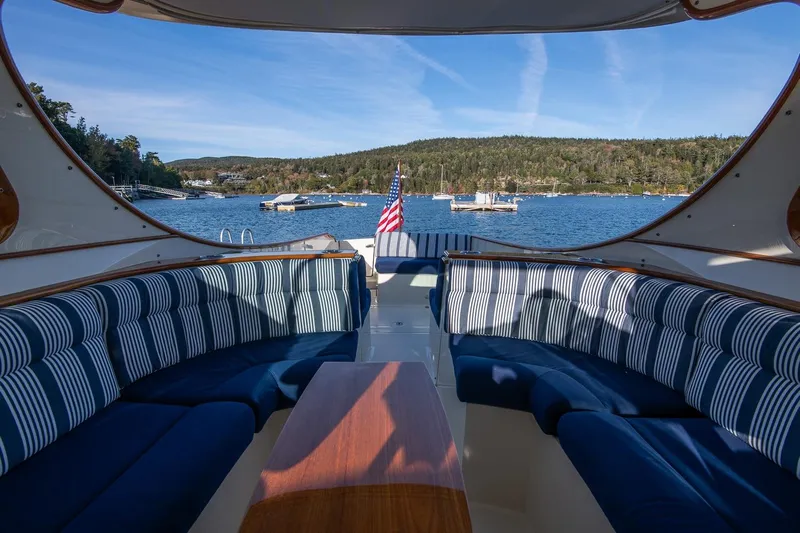 Glory Yacht Photos Pics Luxurious 2013 Hinckley Talaria 34 yacht interior with striped seating, overlooking scenic waterfront.