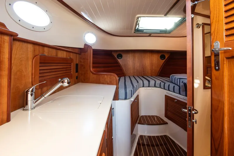 Glory Yacht Photos Pics 2013 Hinckley Talaria 34 interior with wood finish and striped bedding.