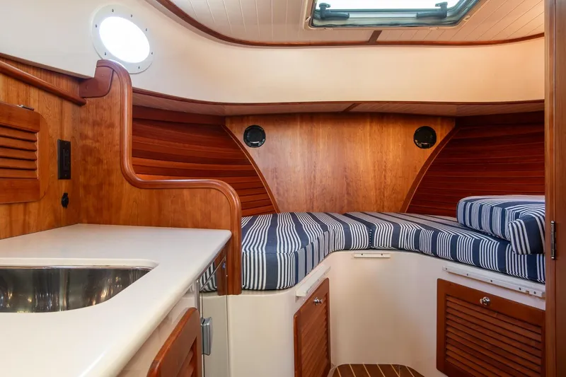 Glory Yacht Photos Pics Interior of 2013 Hinckley Talaria 34 yacht with wood finish and striped cushions.