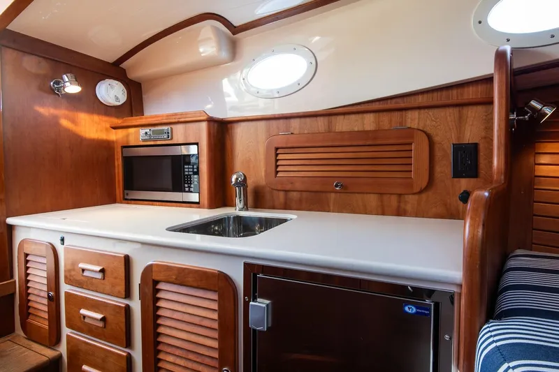 Glory Yacht Photos Pics 2013 Hinckley Talaria 34 yacht interior with wooden cabinetry and modern kitchen amenities.
