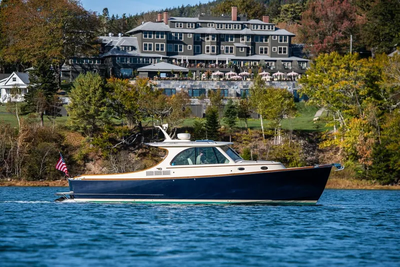 Glory Yacht Photos Pics 2013 Hinckley Talaria 34 cruising on a scenic lake with a grand hotel backdrop.