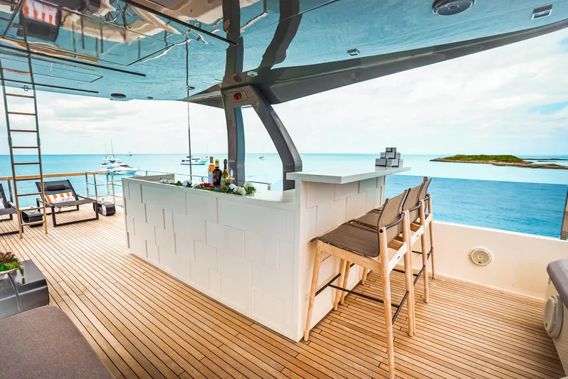 Fifi Yacht Photos Pics Luxurious 2018 Custom Line Navetta 33 yacht deck with bar, ocean view, and seating area.