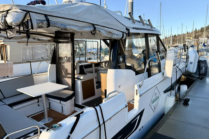  Yacht Photos Pics 2022 Jeanneau NC Weekender 895 docked, featuring outdoor seating and covered cockpit.