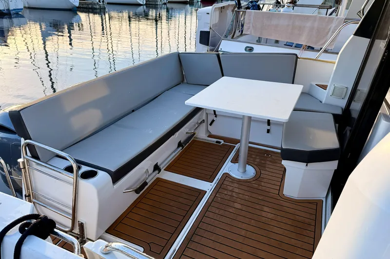  Yacht Photos Pics 2022 Jeanneau NC Weekender 895 boat interior with seating and table, docked at marina.