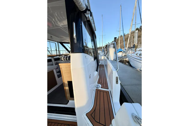  Yacht Photos Pics 2022 Jeanneau NC Weekender 895 docked, showcasing sleek design and wooden deck details.