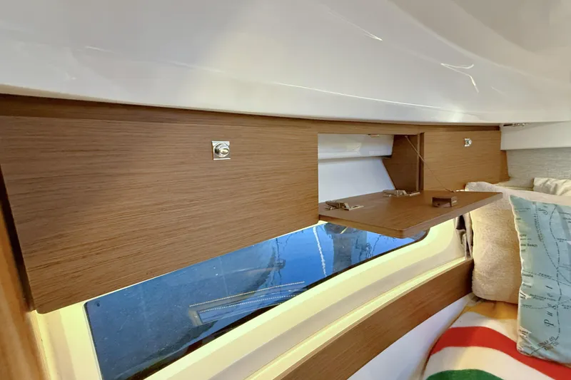  Yacht Photos Pics Interior of 2022 Jeanneau NC Weekender 895 with wooden cabinetry and window view.