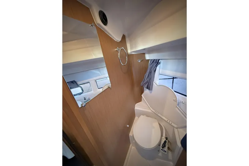  Yacht Photos Pics Bathroom interior of 2022 Jeanneau NC Weekender 895 boat, featuring toilet and mirror.