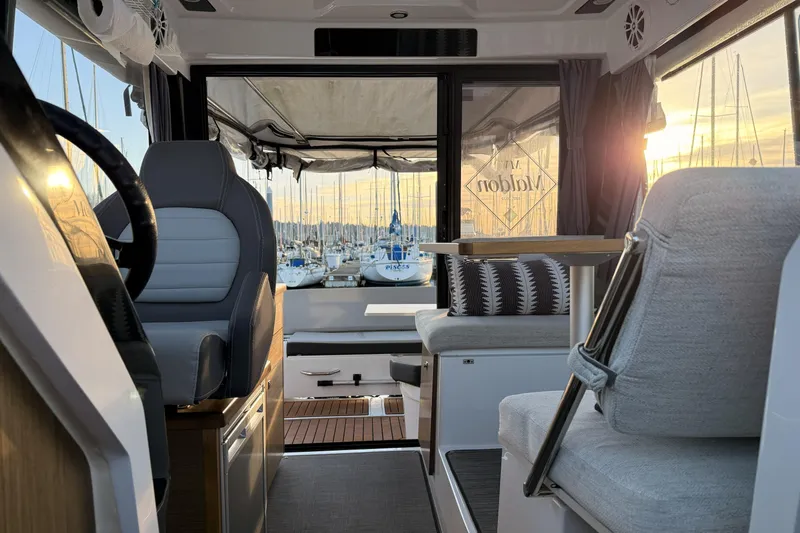  Yacht Photos Pics Interior of 2022 Jeanneau NC Weekender 895 boat with marina view at sunset.
