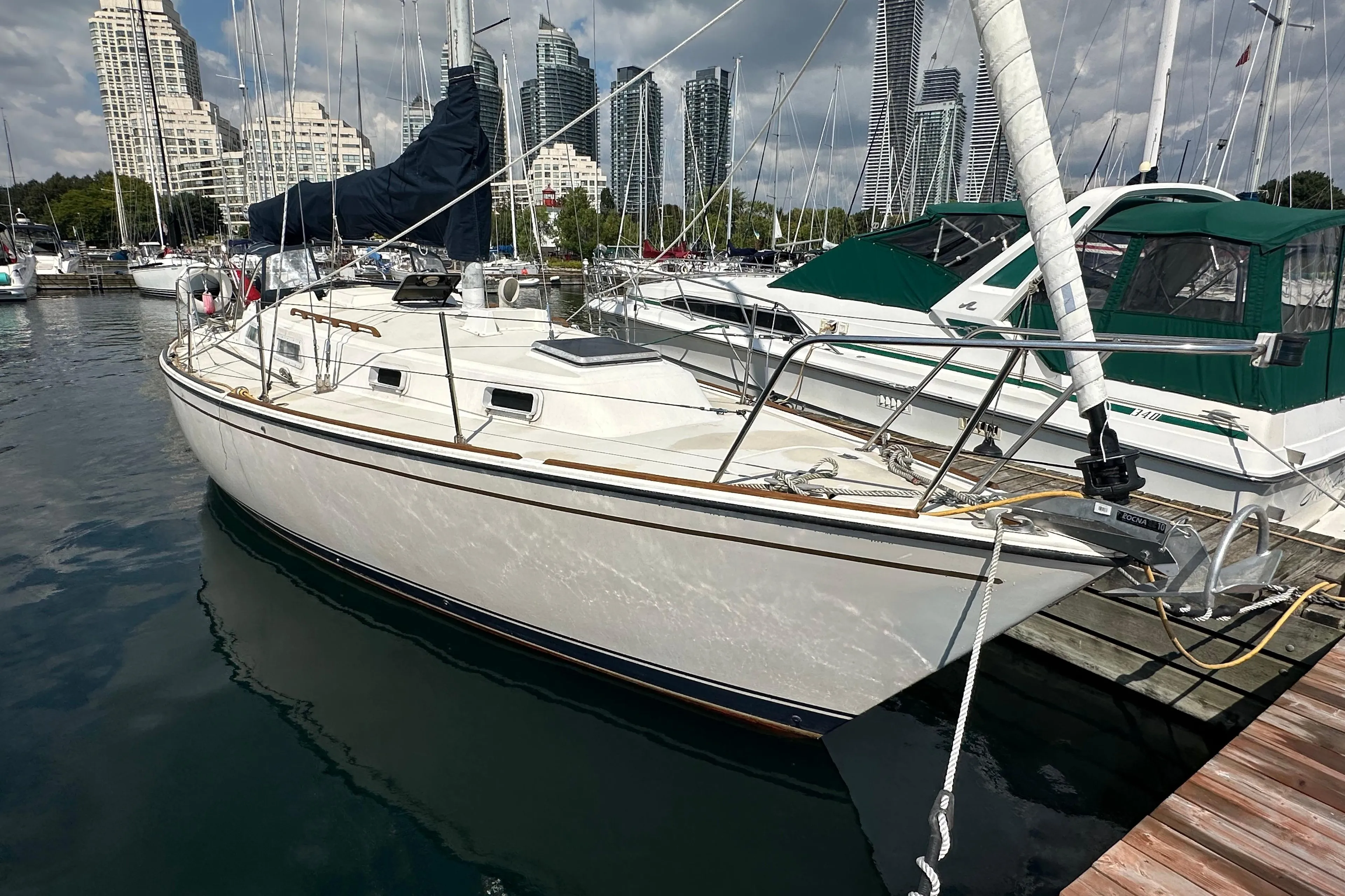 1984 Pearson 34 sailboat docked in marina with city skyline background.