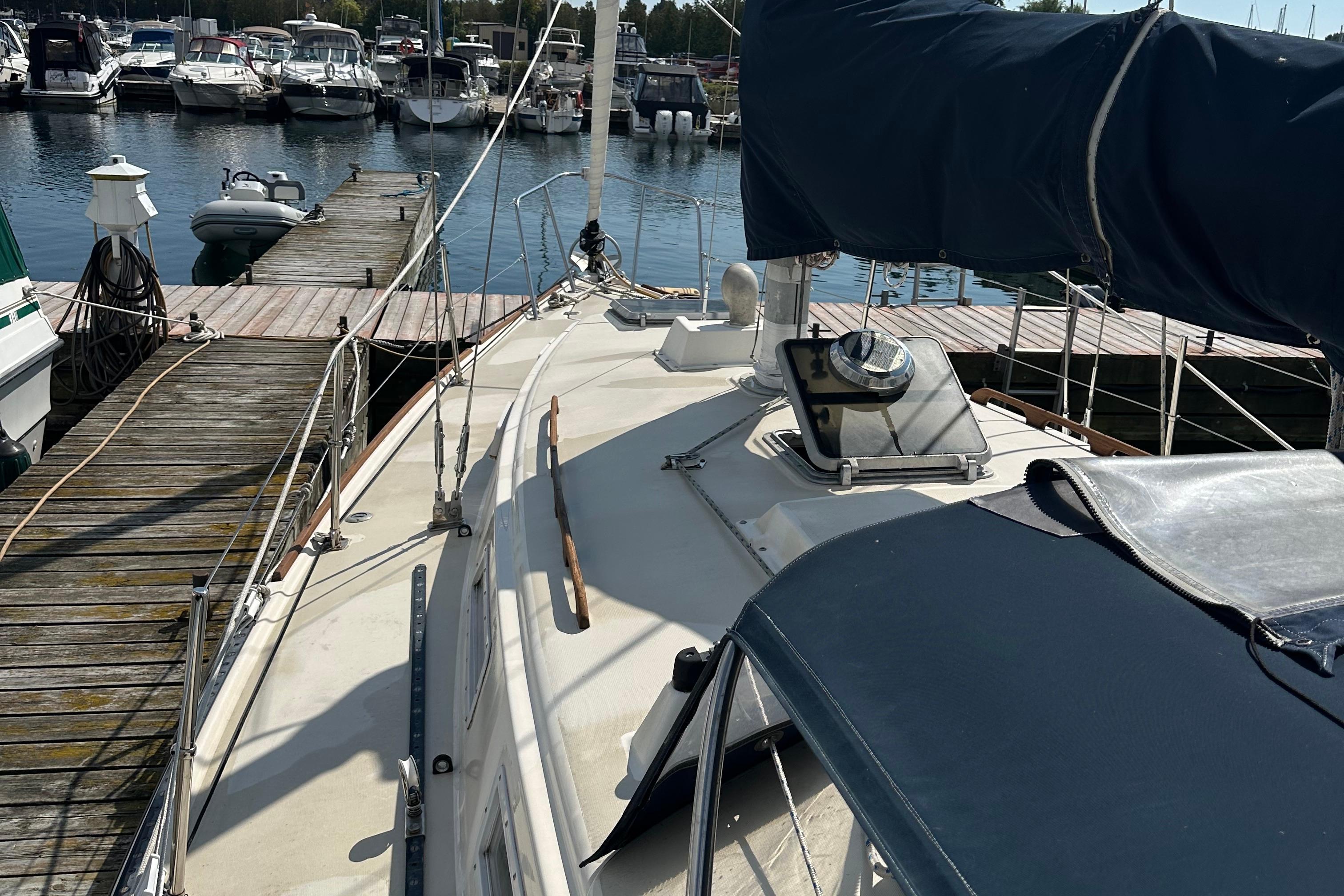 1984 Pearson 34 sailboat docked at marina, surrounded by other boats.