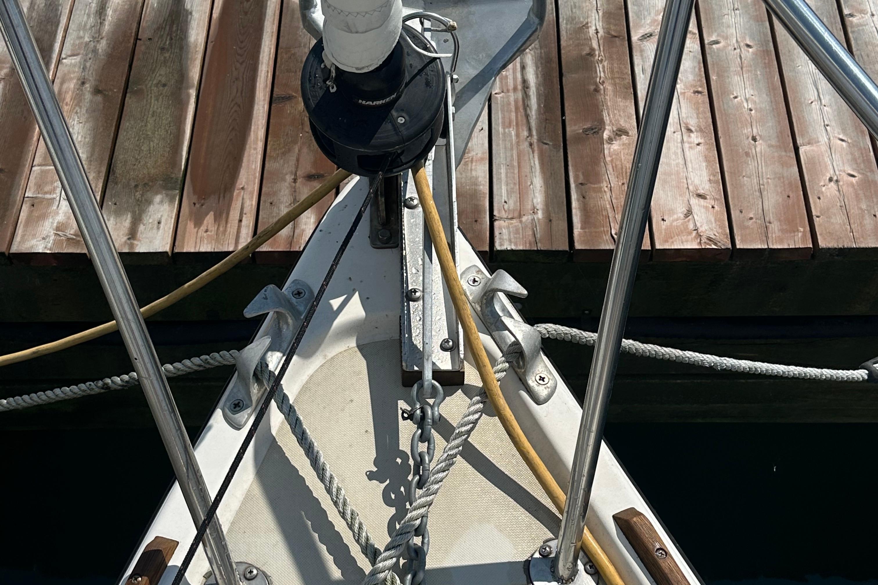 Bow of 1984 Pearson 34 sailboat docked, showing ropes and deck details.