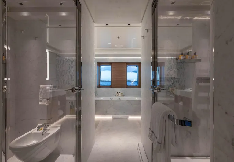 Moonstone Yacht Photos Pics Luxurious bathroom on Amels 200 yacht, featuring elegant marble design and ocean view window.