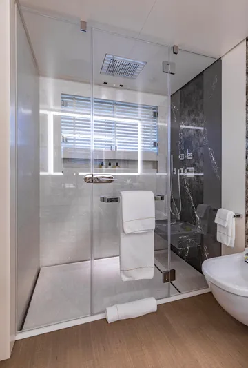 Moonstone Yacht Photos Pics Luxurious bathroom in 2021 Amels 200 yacht with glass shower and modern fixtures.