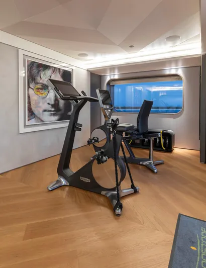 Moonstone Yacht Photos Pics Luxury yacht gym with exercise bike, modern decor, and ocean view window on Amels 200, 2021.