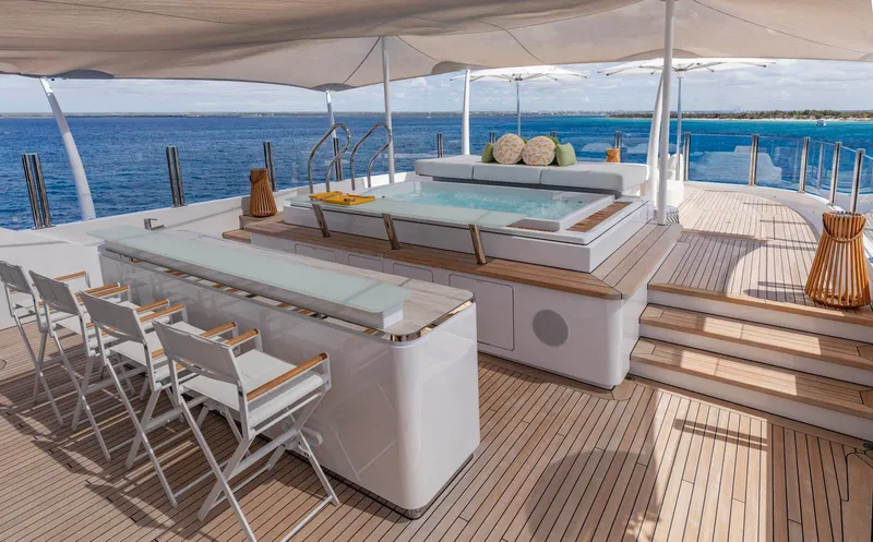 Moonstone Yacht Photos Pics Luxurious Amels 200 yacht deck with bar, seating, and jacuzzi, overlooking the ocean.