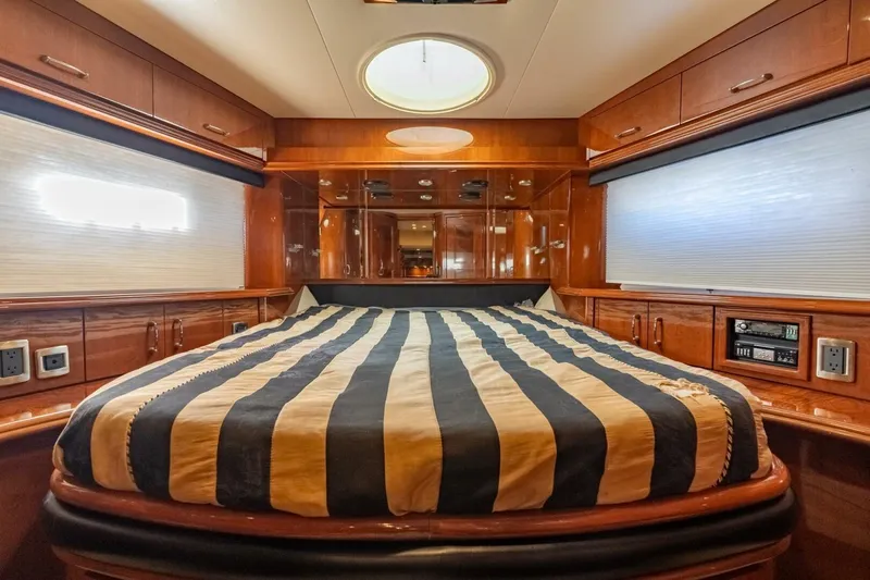Magic Moments Yacht Photos Pics Luxurious 2006 Marquis 59 yacht bedroom with striped bedding and elegant wood finishes.