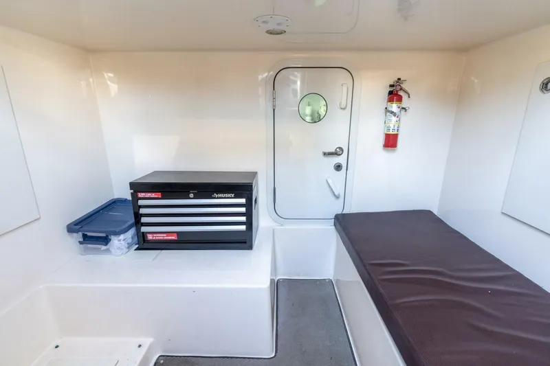 Magic Moments Yacht Photos Pics Interior of 2006 Marquis 59 yacht with toolbox, fire extinguisher, and cushioned bench.