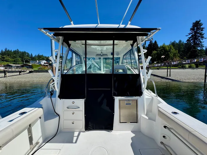  Yacht Photos Pics 2018 Boston Whaler 285 Conquest boat docked by scenic shoreline.