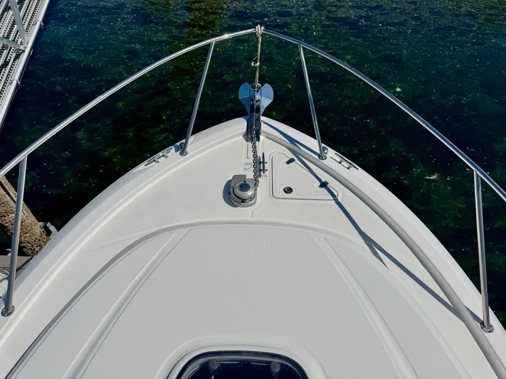 Yacht Photos Pics Bow of 2018 Boston Whaler 285 Conquest boat with anchor, docked on clear water.