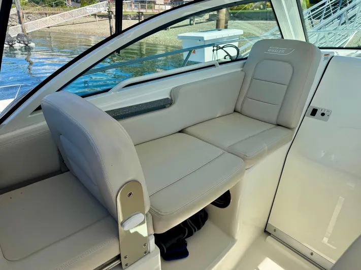  Yacht Photos Pics 2018 Boston Whaler 285 Conquest interior seating with beige upholstery, dockside view.