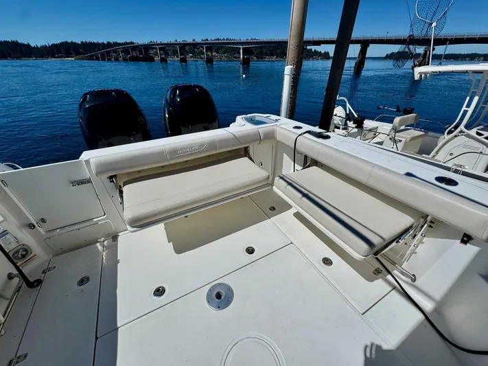  Yacht Photos Pics 2018 Boston Whaler 285 Conquest boat deck with seating, overlooking a scenic waterway and bridge.
