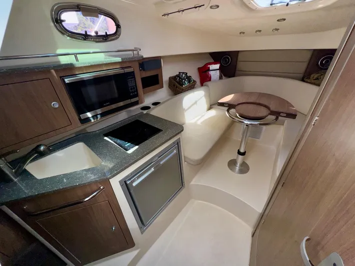  Yacht Photos Pics 2018 Boston Whaler 285 Conquest cabin interior with kitchenette and seating area.