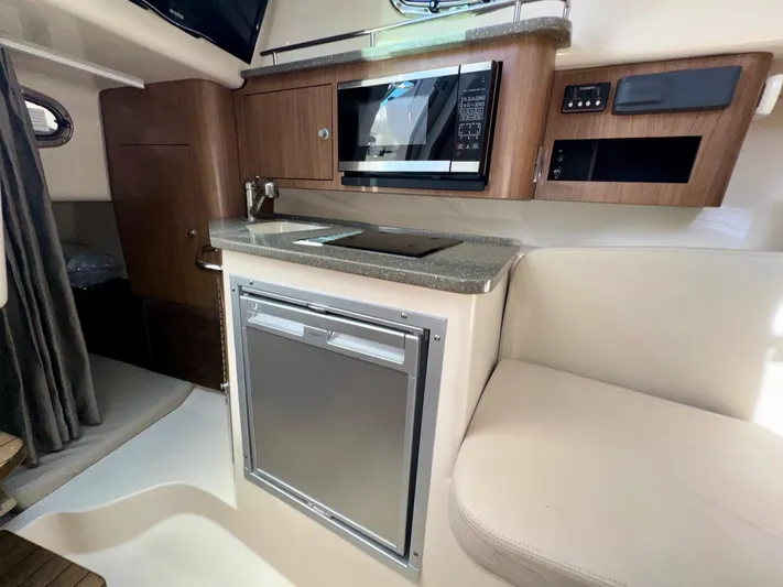  Yacht Photos Pics 2018 Boston Whaler 285 Conquest cabin interior with kitchenette and seating area.
