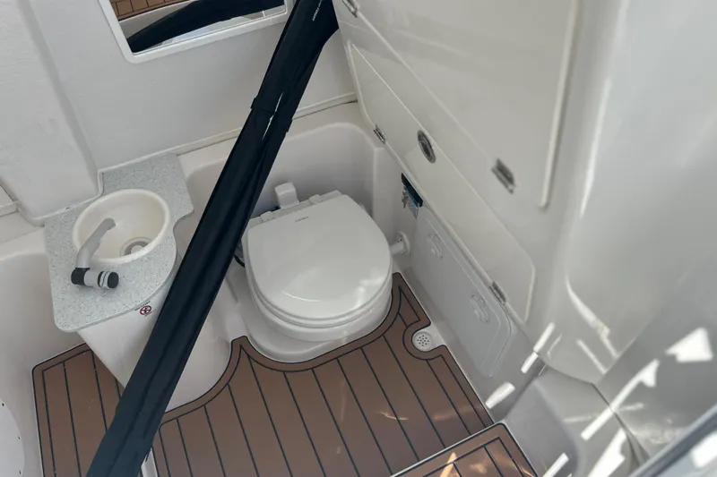  Yacht Photos Pics 2026 Sea Fox 268 Commander boat bathroom with toilet, sink, and wooden flooring.