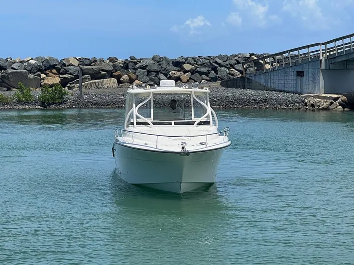  Yacht Photos Pics 2008 Hydra-Sports 3500VX boat navigating near rocky shoreline and bridge.