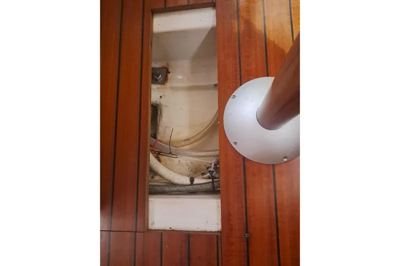 Anyroad Yacht Photos Pics Wooden deck of 2006 Beneteau 423 yacht, showing open hatch with visible hoses.