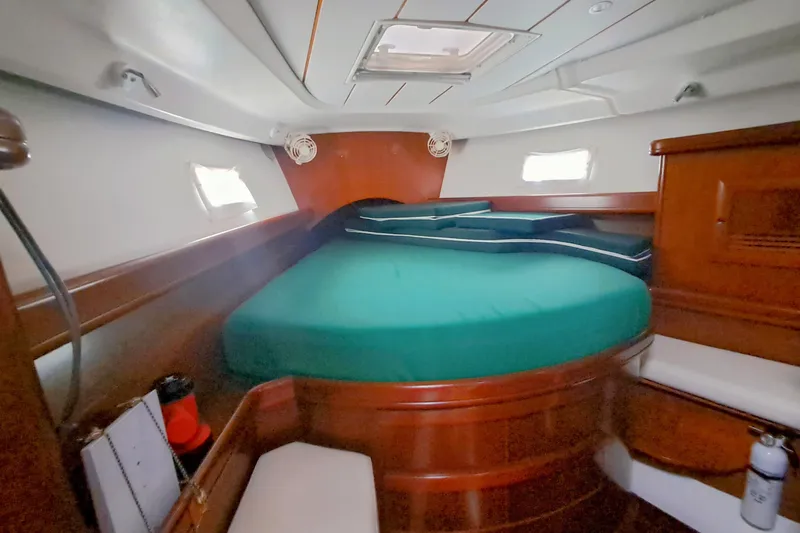 Anyroad Yacht Photos Pics Cozy cabin interior of 2006 Beneteau 423 sailboat with green bedding and wooden furnishings.