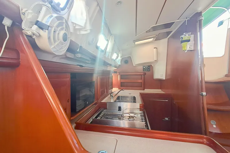 Anyroad Yacht Photos Pics Interior of 2006 Beneteau 423 sailboat, featuring a compact kitchen with wood cabinetry.