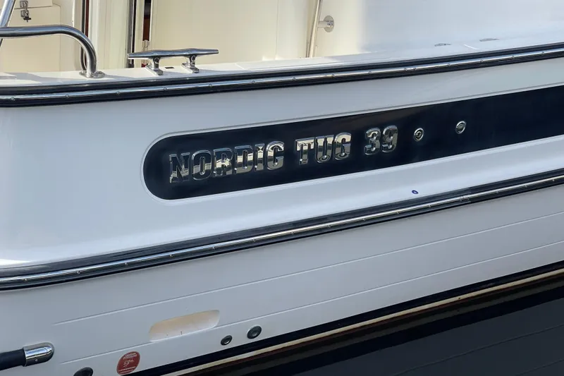 Spray Yacht Photos Pics 2015 Nordic Tug 39 Flybridge boat nameplate, sleek design, close-up view.