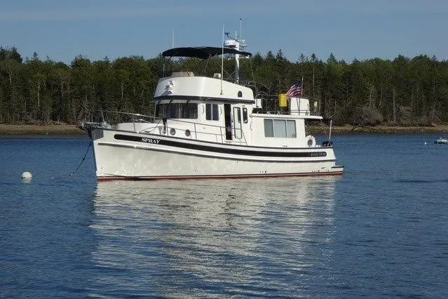 Spray Yacht Photos Pics 2015 Nordic Tug 39 Flybridge boat on calm water with forested shoreline.