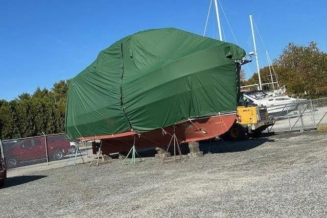 Spray Yacht Photos Pics 2015 Nordic Tug 39 Flybridge covered in green tarp at a boatyard.