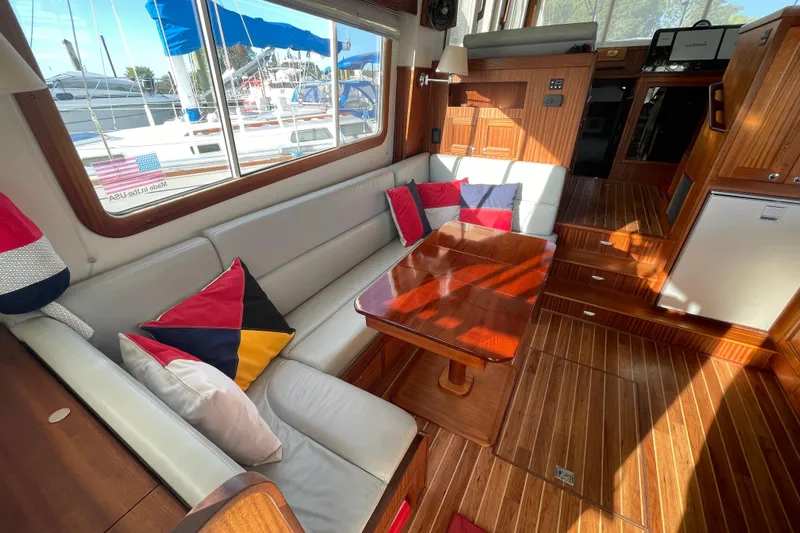 Spray Yacht Photos Pics Luxurious interior of a 2015 Nordic Tug 39 with elegant wood finish and colorful cushions.