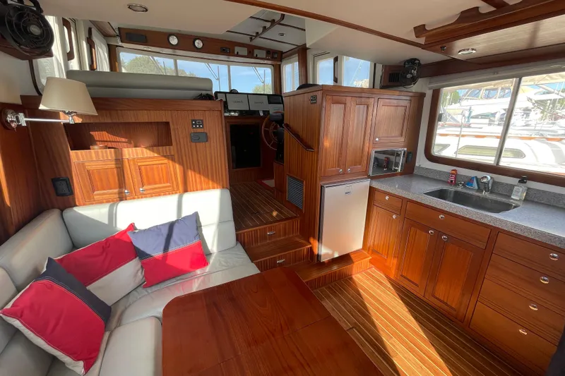 Spray Yacht Photos Pics Interior of 2015 Nordic Tug 39 with wood cabinetry, seating, and kitchenette.