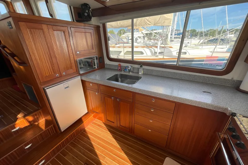 Spray Yacht Photos Pics 2015 Nordic Tug 39 interior kitchen with wooden cabinets and marina view.