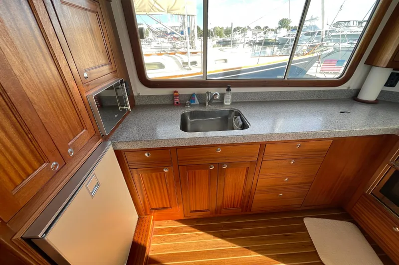 Spray Yacht Photos Pics Interior of 2015 Nordic Tug 39, featuring a wooden kitchen with sink and window view.